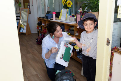 Educator and child packing bag