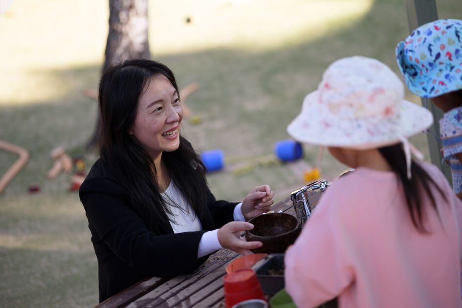 Sandy smiling at children mud kitchen