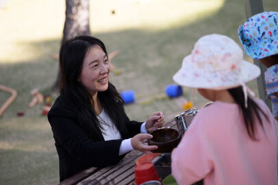 Sandy smiling at children mud kitchen