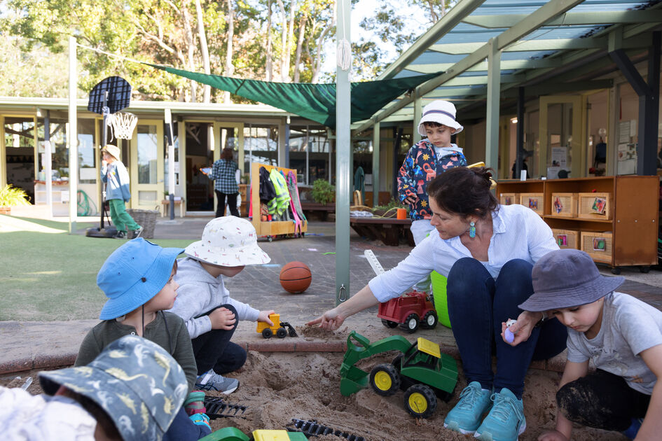Educator with children in sandpit