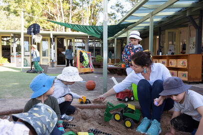 Educator with children in sandpit