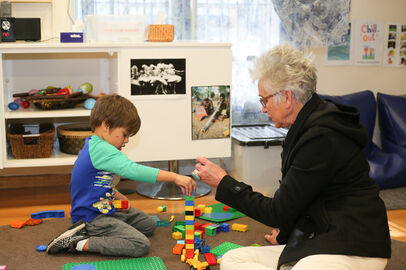 Boy and educator playing with duplo