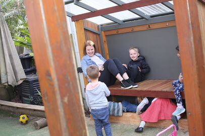 Educator and children smiling and talking outside