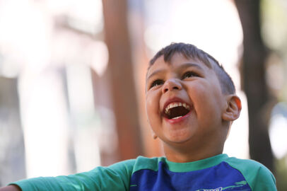 Boy in blue shirt laughing up close