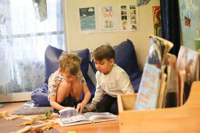 Two boys reading book intently together