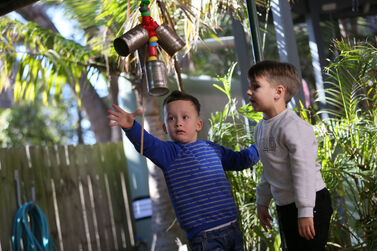 Boys playing with hanging cans outside