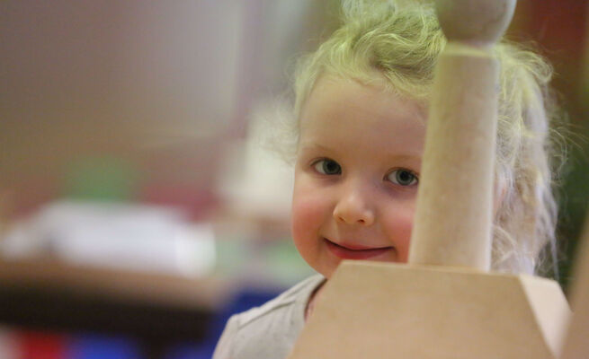 Close up of girl through block tower