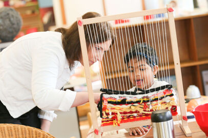 Mika and girl at weaving frame