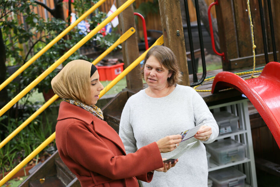 Linda and educator standing and talking with resource