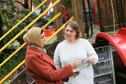 Linda and educator standing and talking with resource