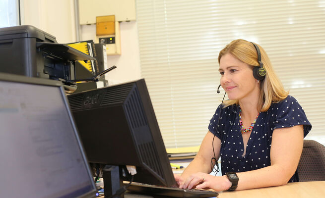 Bel at computer with headphones