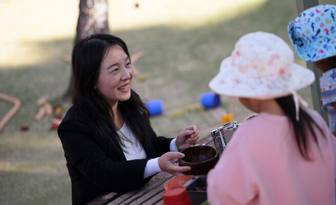Sandy smiling at children mud kitchen