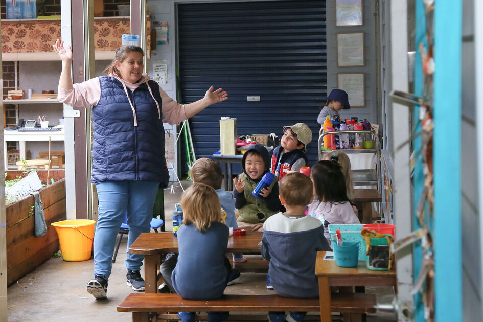 Educator with children laughing together at lunch time 1