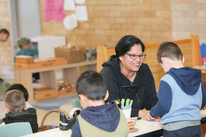 Educator with children at table smiling