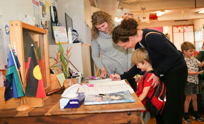 Adults and child at sign in table