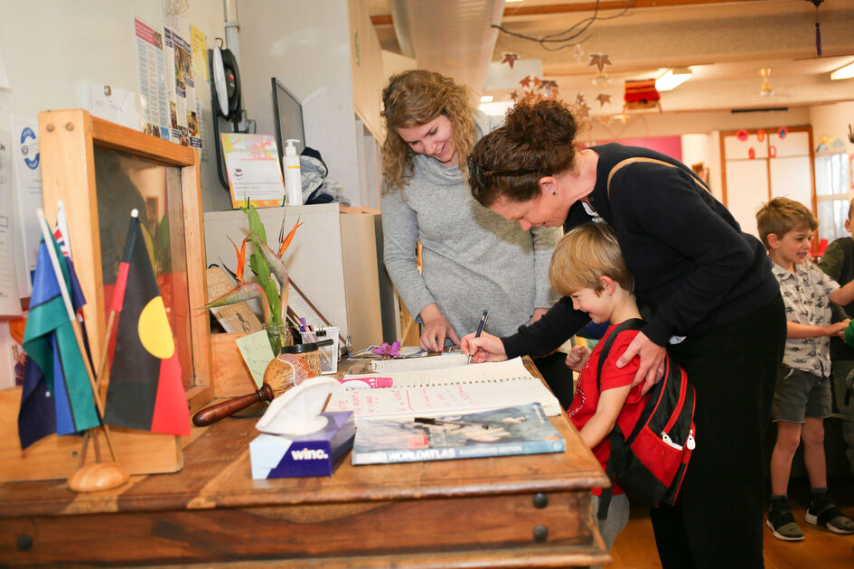 Adults and child at sign in table